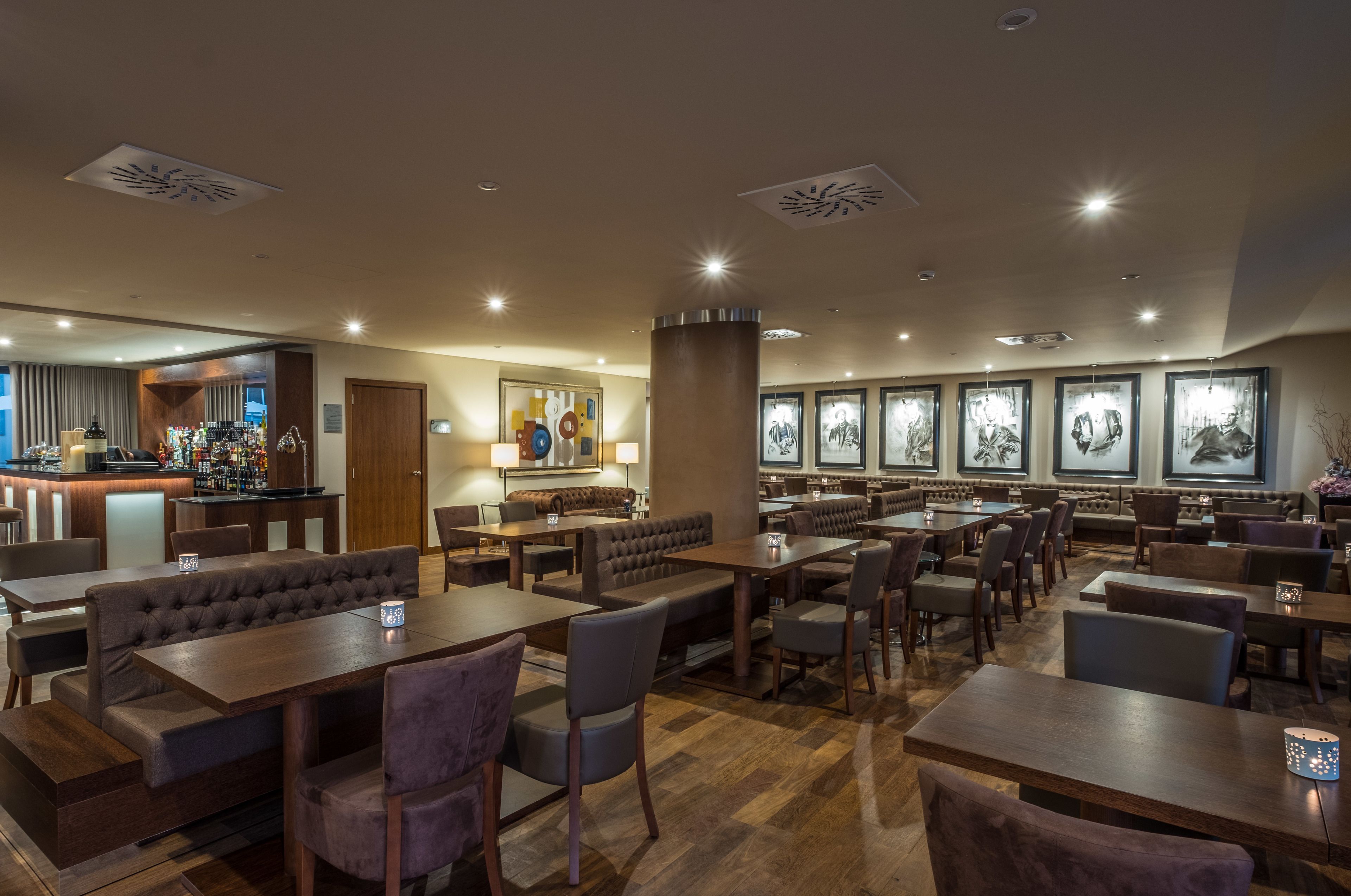 Un restaurant avec des banquettes, des tables et un coin bar.