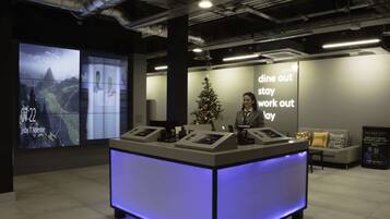 A reception desk with a digital display, a Christmas tree, and a wall with motivational text.