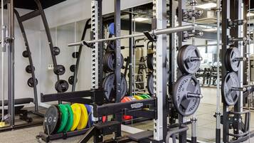 A gym with weightlifting equipment, including barbells and weight plates.