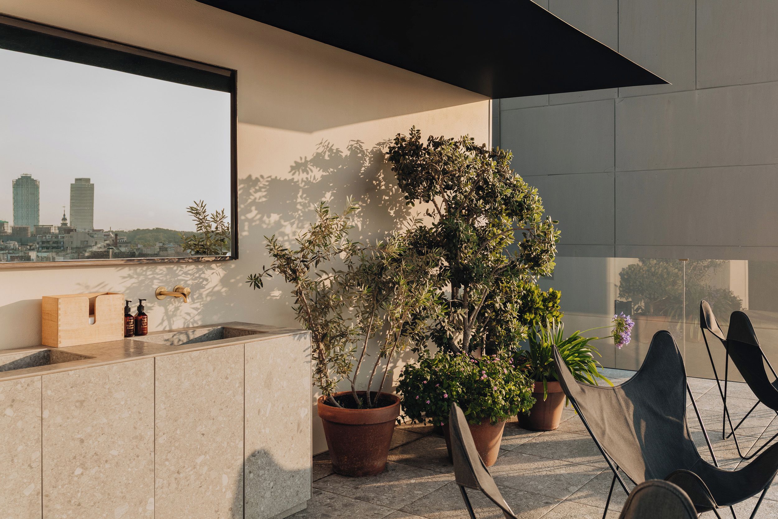 A modern kitchen with a large window, a sink, and a potted plant.