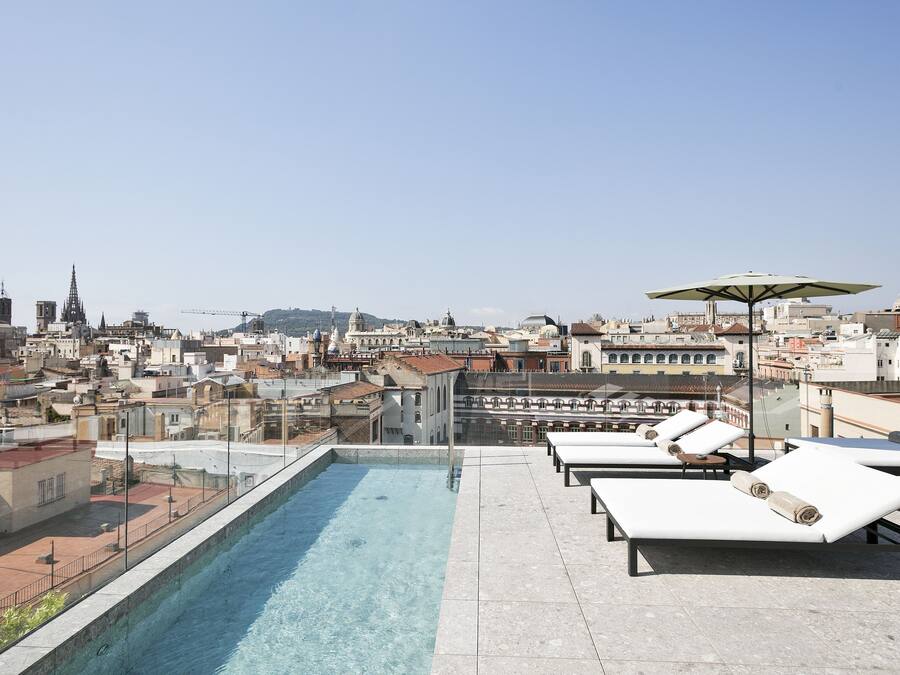 Una piscina al aire libre, sombrillas, tumbonas