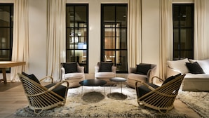 Un salon moderne comprenant un canapé, deux fauteuils, une table basse et un tapis.