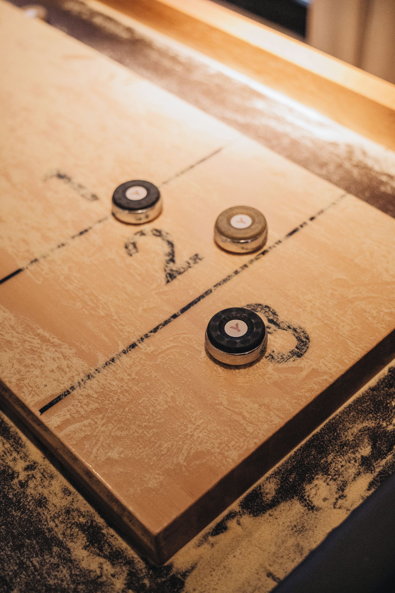 A close-up of a shuffleboard table with numbered scoring areas.