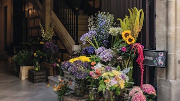 Un'arrangiazione floreale in una hall con una scalinata e un cartello che recita 'Passage Flowers'.