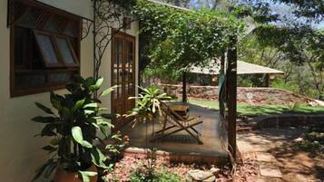 A house with a wooden porch, a potted plant, and a small table.