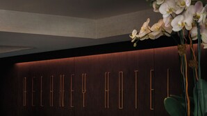 A reception desk with a dark wooden panel and illuminated letters spelling "BELAN HOTEL". - The Delaney Hotel (Orlando)