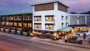 Ein modernes Hotel mit Glasfassade, Außenbereich und einem gut beleuchteten Eingang.