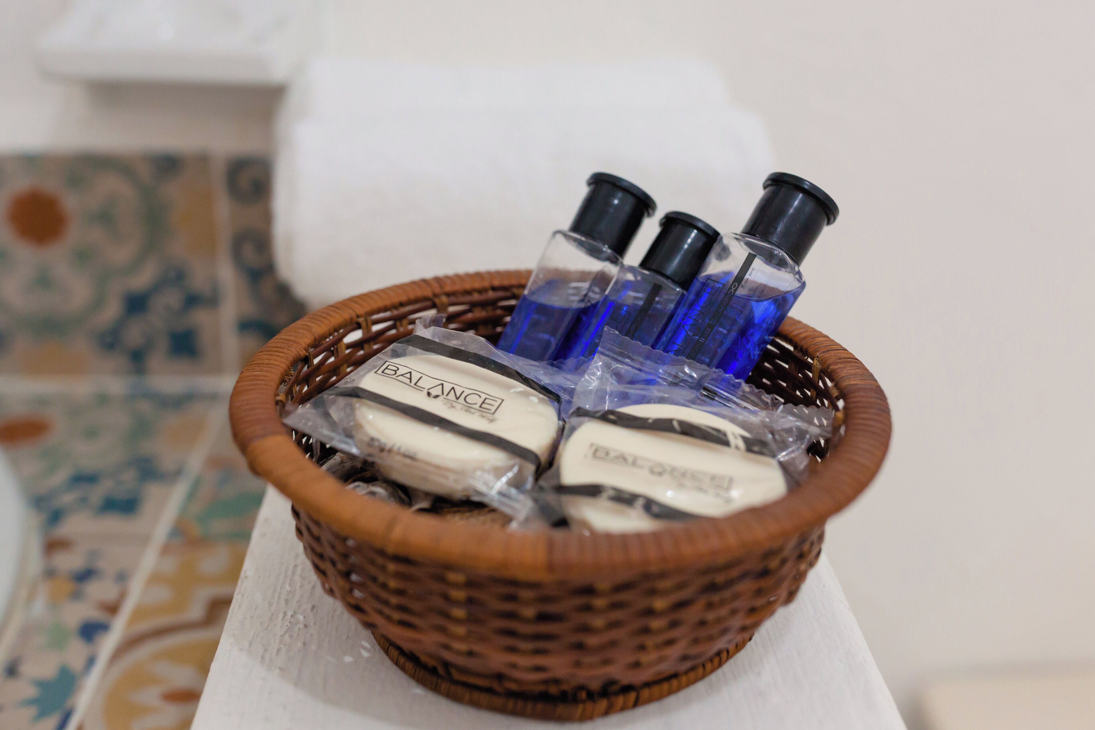 A wicker basket containing toiletries on a white surface.
