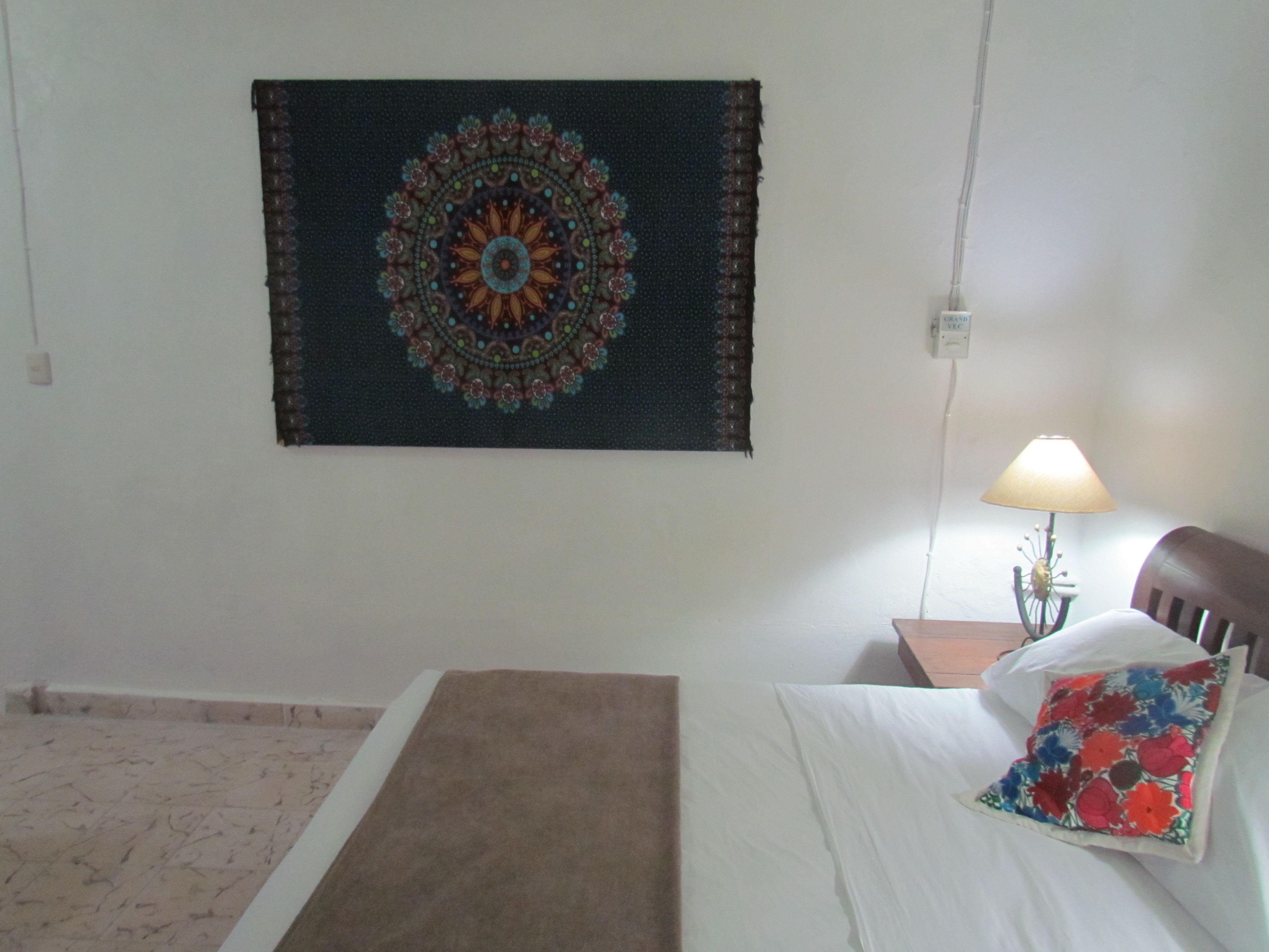Une chambre à coucher avec un lit, une table de chevet, une lampe et un tableau ou une décoration murale.