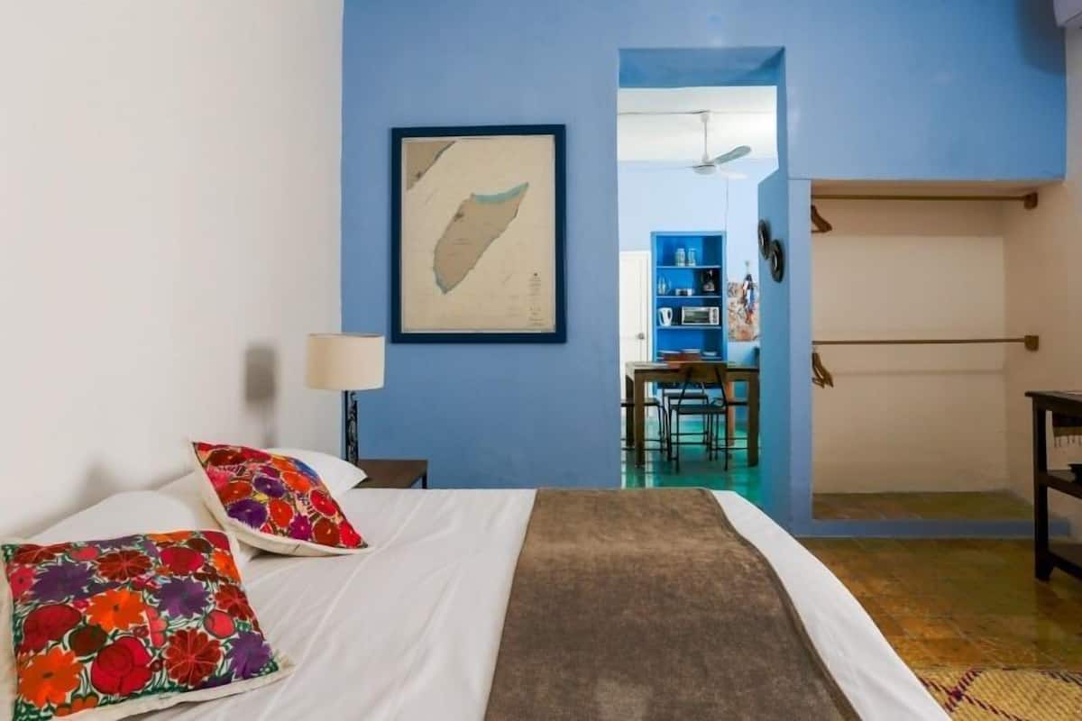 Ein Hotelzimmer mit Bett, Kissen, einer Karte an der Wand, einem Schreibtisch und einem Stuhl.