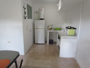 Enjoy cooking in this well-lit kitchen with a refrigerator, sink, and microwave.