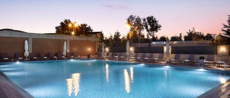 Una piscina cubierta, una piscina al aire libre de temporada, sombrillas