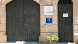 Ein Steinhaus mit zwei großen Holztüren, eine beschriftet mit "Casa Finestra" und die andere mit einem "H"-Schild.