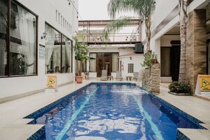 Una piscina al aire libre, tumbonas