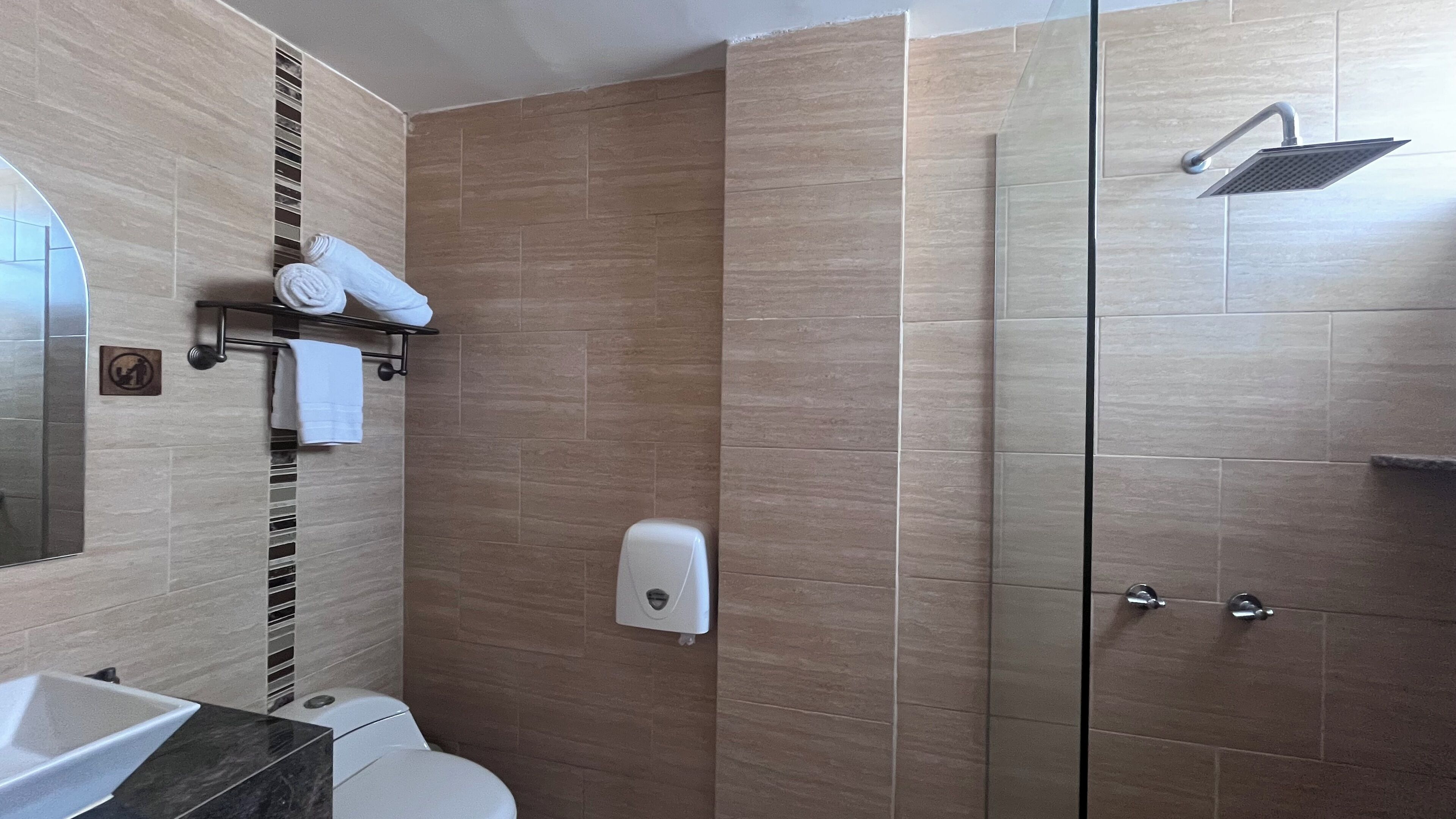 Une salle de bain moderne équipée d’une douche, de toilettes et d’un lavabo.