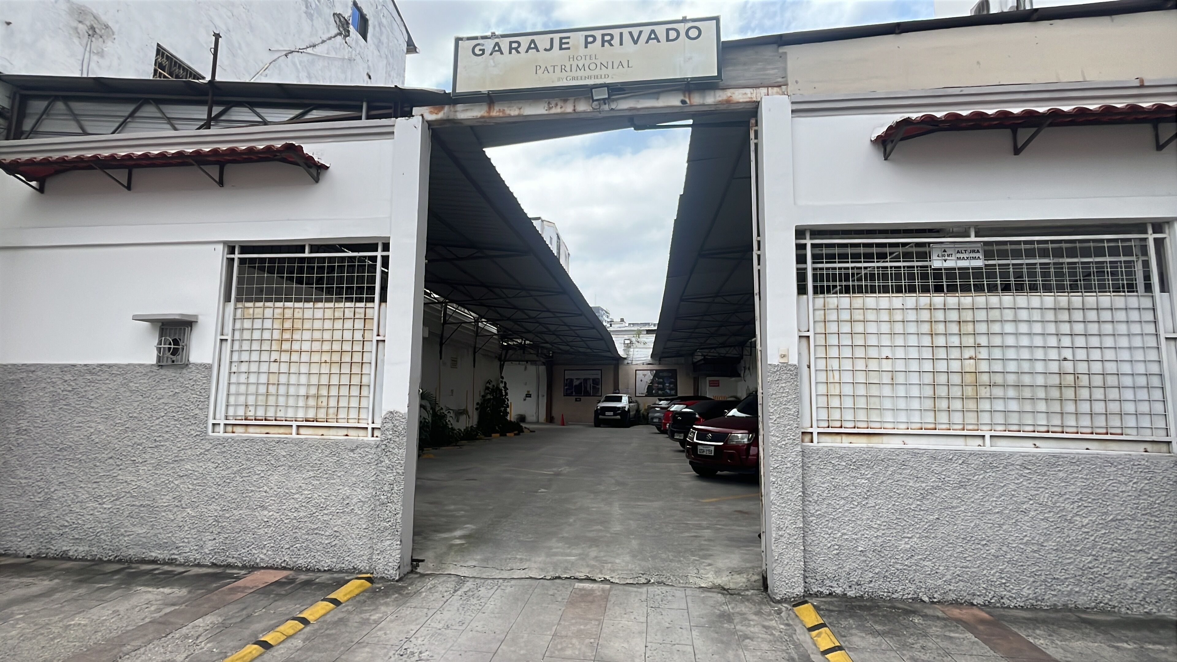 Entrada de garagem privativa com placa indicando 'GARJA PRIVADO HOTEL PATRIMONIAL BY GREENFIELD'.