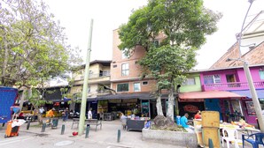 Une scène de rue avec des terrasses et divers commerces.