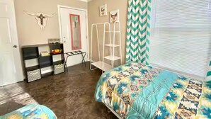 A bedroom with a bed, a wardrobe, a chair, and a window with curtains. - The Lorena Ranchette- Goats, Firepit, Hammock (Lorena)