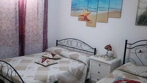Un dormitorio con cama, mesita de noche y estante en la pared.
