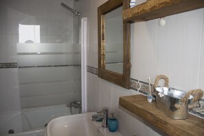 Tina con regadera, secadora de cabello, bidet, toallas 