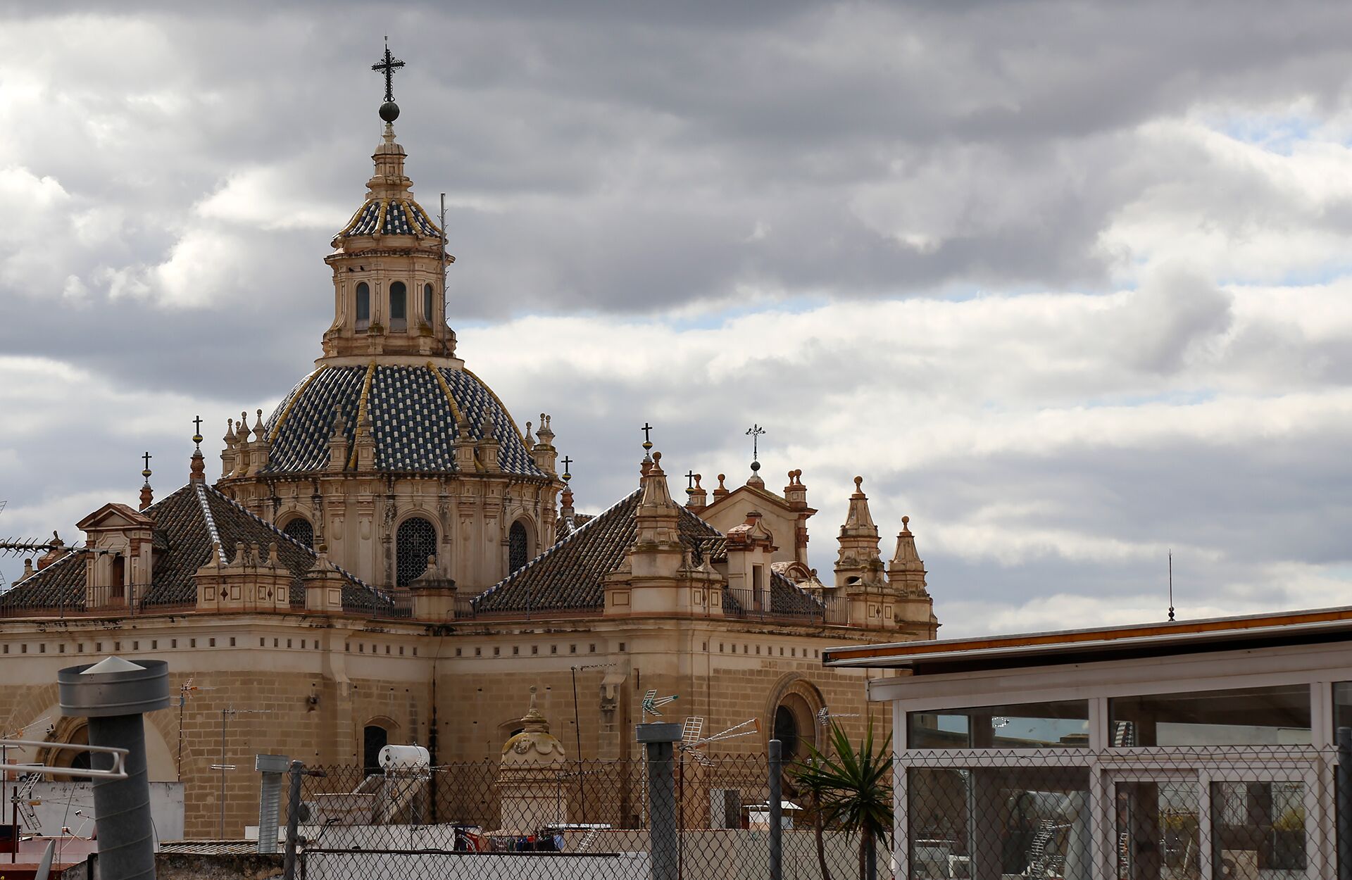 A historic building with a prominent dome and multiple spires, surrounded by a fence.