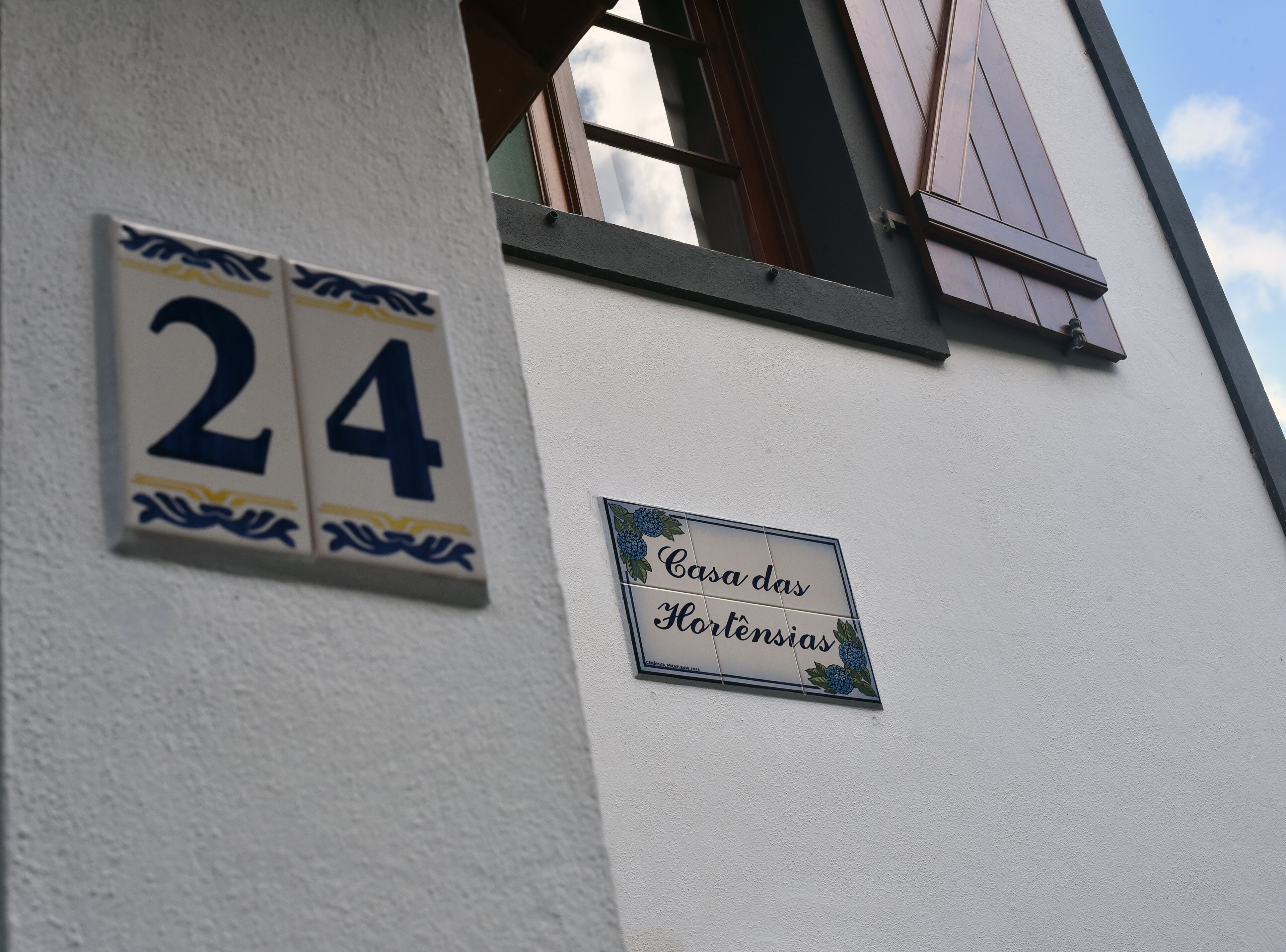 A building with a white exterior, a number '24' sign, and a sign reading 'Casa das Hortências'.