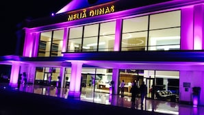 A building with a sign reading "MELIA DUNAS" and large windows.