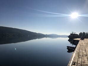 Ein ruhiger See mit einer hölzernen Mole, die ins Wasser hineinreicht.