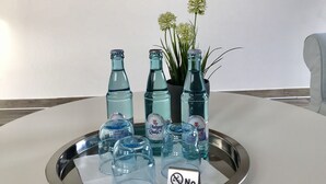 Una mesa con botellas de agua Auburn, un cartel de no fumar y una planta en maceta.