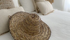 A neatly made bed with a woven basket, two pillows, and a lamp on a white wall. - Algarve - Altura Magnificent semi-detached villa with private enclosed garden (8950 Altura)