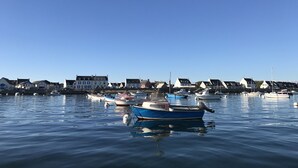 A marina with several boats docked, surrounded by buildings with a uniform architectural style. - Penmarc’h-Holiday Cottage (Penmarch)