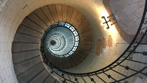 A spiral staircase with a brick wall and metal railing. - Penmarc’h-Holiday Cottage (Penmarch)