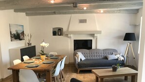 A living room with a sofa, dining table, chairs, and a coffee table. - Penmarc’h-Holiday Cottage (Penmarch)