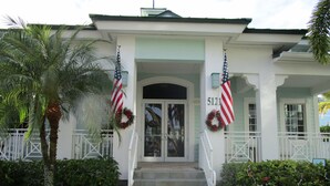 A building with a white facade, a number '5121' above the entrance, and two American flags with wreaths.