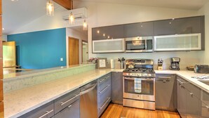 A modern kitchen with stainless steel appliances, a built-in microwave, and a gas stove. - Mid Century Home with a Modern Twist in Downtown. Proximate to Everything w/AC! (Glenwood Springs)