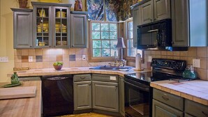 A kitchen with grey cabinets, a dishwasher, a stove, and a microwave.