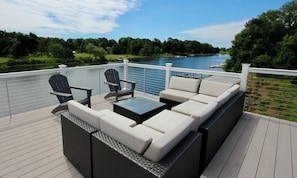 Une terrasse dotée de mobilier d’extérieur, offrant une vue sur un lac.