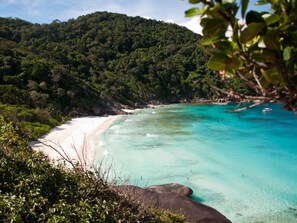 A beach with clear turquoise water, white sand, and lush green hills in the background. - Casacool Hotel Khoalak (Takua Pa)