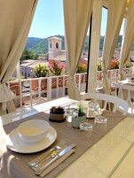 Mesa lista para dos con vistas a un paisaje montañoso y la torre de una iglesia.