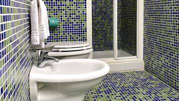 A bathroom with a toilet, sink, and shower.
