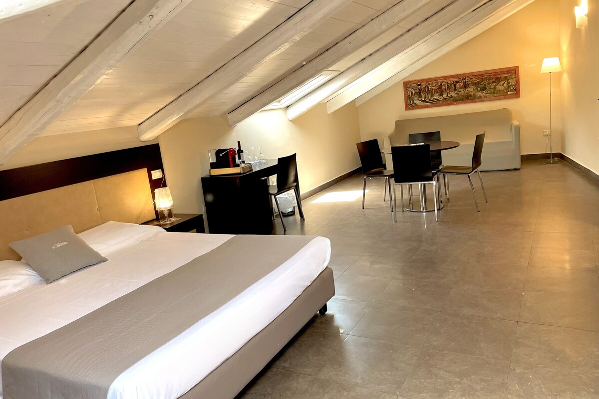 Una habitación de hotel con cama, escritorio, sillas y una mesa de comedor.