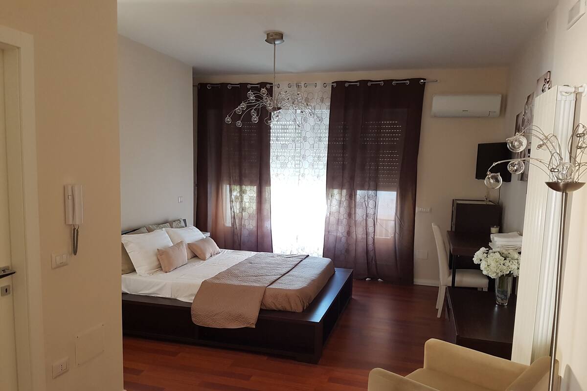 Une chambre à coucher avec un grand lit, un bureau et une chaise.