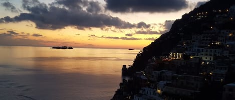 Un pueblo costero al atardecer con edificios a lo largo del acantilado.