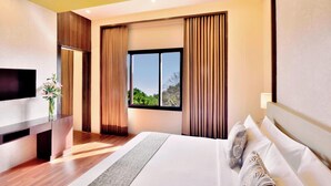 A modern hotel room with a large bed, a flat-screen TV, a wooden desk, and a window with curtains. - Four Points By Sheraton Srinagar (Srinagar)