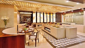 A modern dining area with a central island, seating, and a patterned floor. - Four Points By Sheraton Srinagar (Srinagar)
