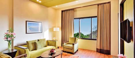 Una sala de estar moderna con un sofá, sillones, una mesa de centro y un televisor.