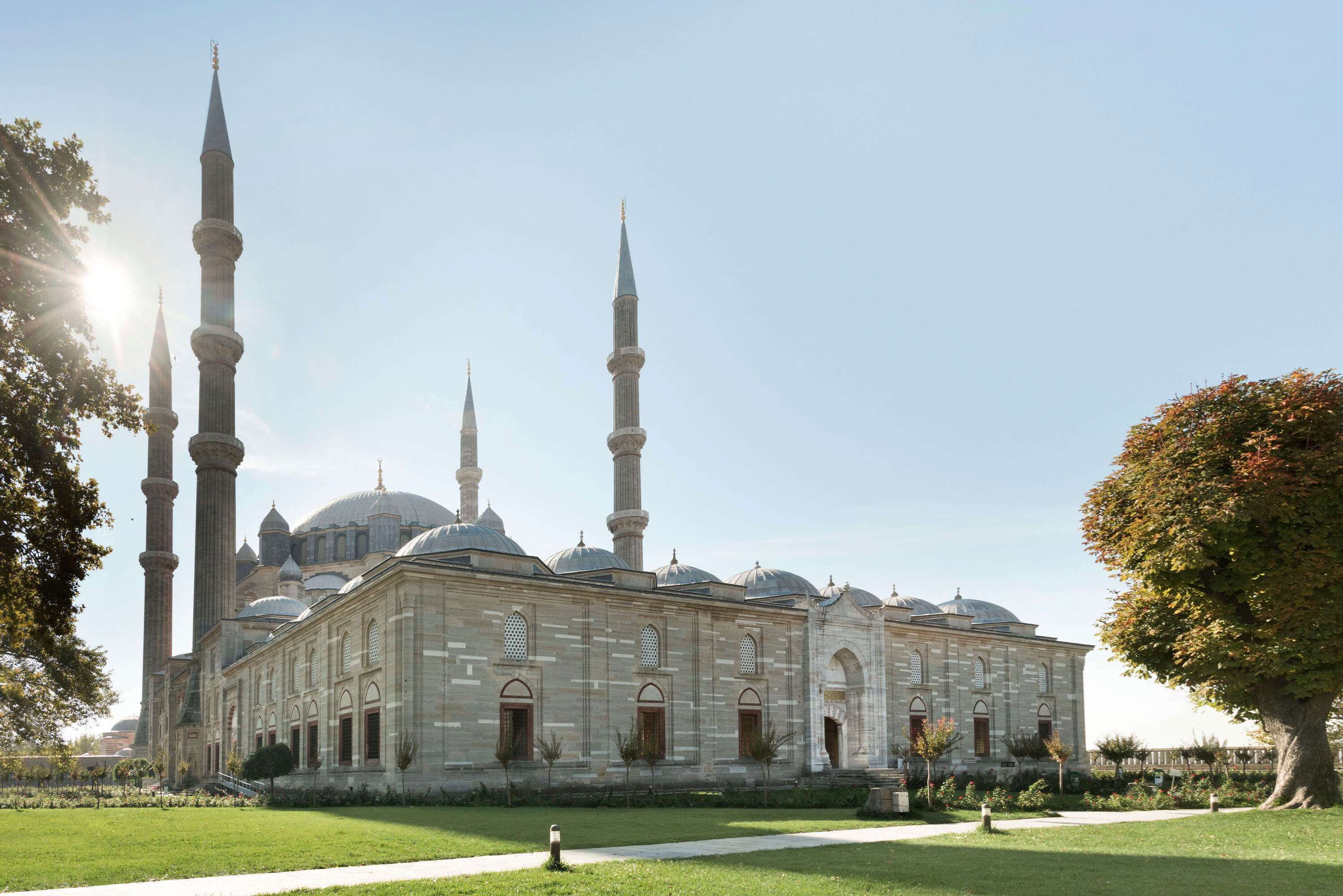 A large mosque with multiple minarets and domes, surrounded by a well-maintained garden.
