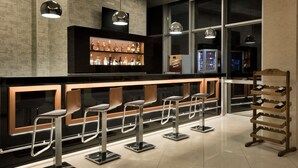 A bar area with stools, a shelf of bottles, and a wine rack. - Ramada Hotel & Suites by Wyndham Edirne (Edirne)