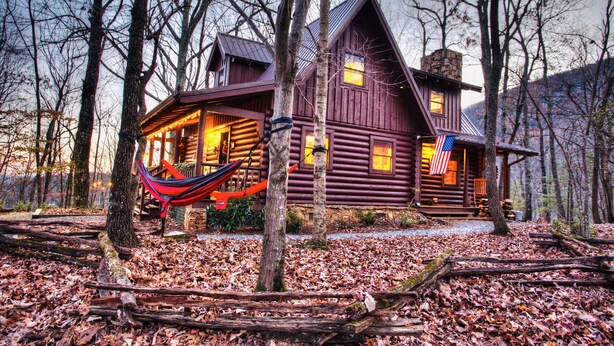 A rustic log cabin with a porch and a hammock, surrounded by trees and fallen leaves. - Sitting on 20 beautiful acres, totally secluded, Just 6 miles from Helen, GA! (Sautee Nacoochee)