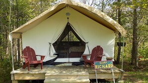 A glamping site named Glamp Richard, featuring a tent with two red Adirondack chairs and a wooden deck. - GLAMP RICHARD ON ADIRONDACK FLOWER FARM (North River)